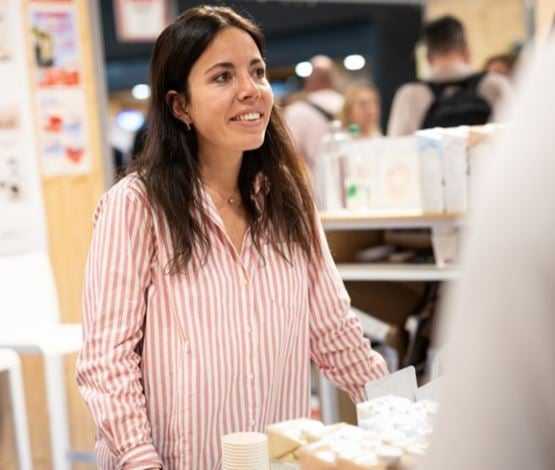Exposante présentant ses produits sur un stand