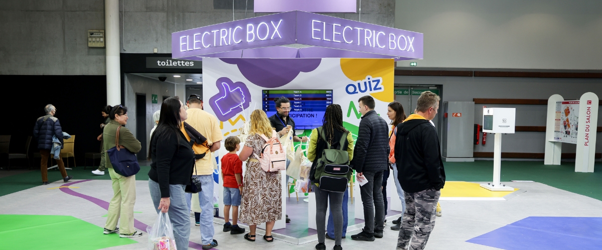 Stand Electric Box avec enseigne lumineuse et visiteurs rassemblés devant un écran lors d’un salon professionnel