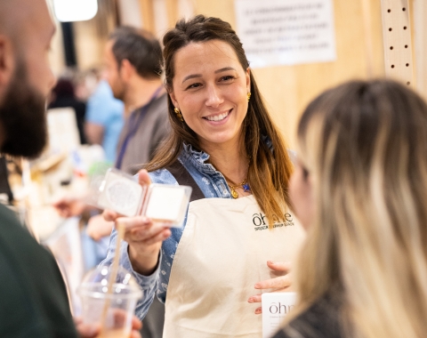 exposante du stand Ohme montrant un produit a des visiteurs