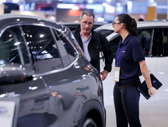 client et vendeur qui discute sur stand de voiture